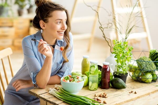 woman eating a bowl of veggies