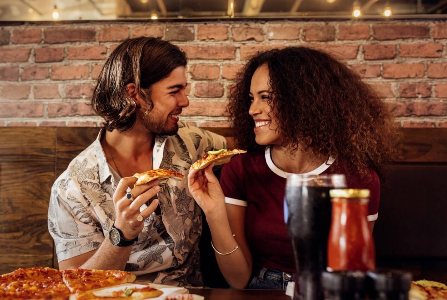 man and woman eating pizza