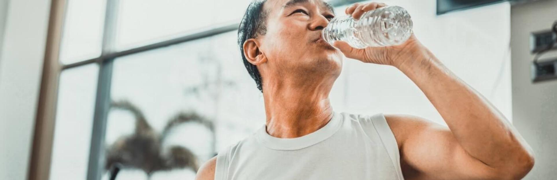 man drinking water in gym