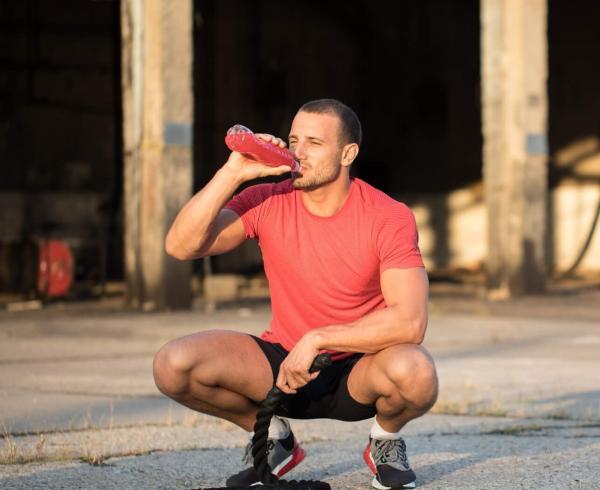 man drinking beverage after workout