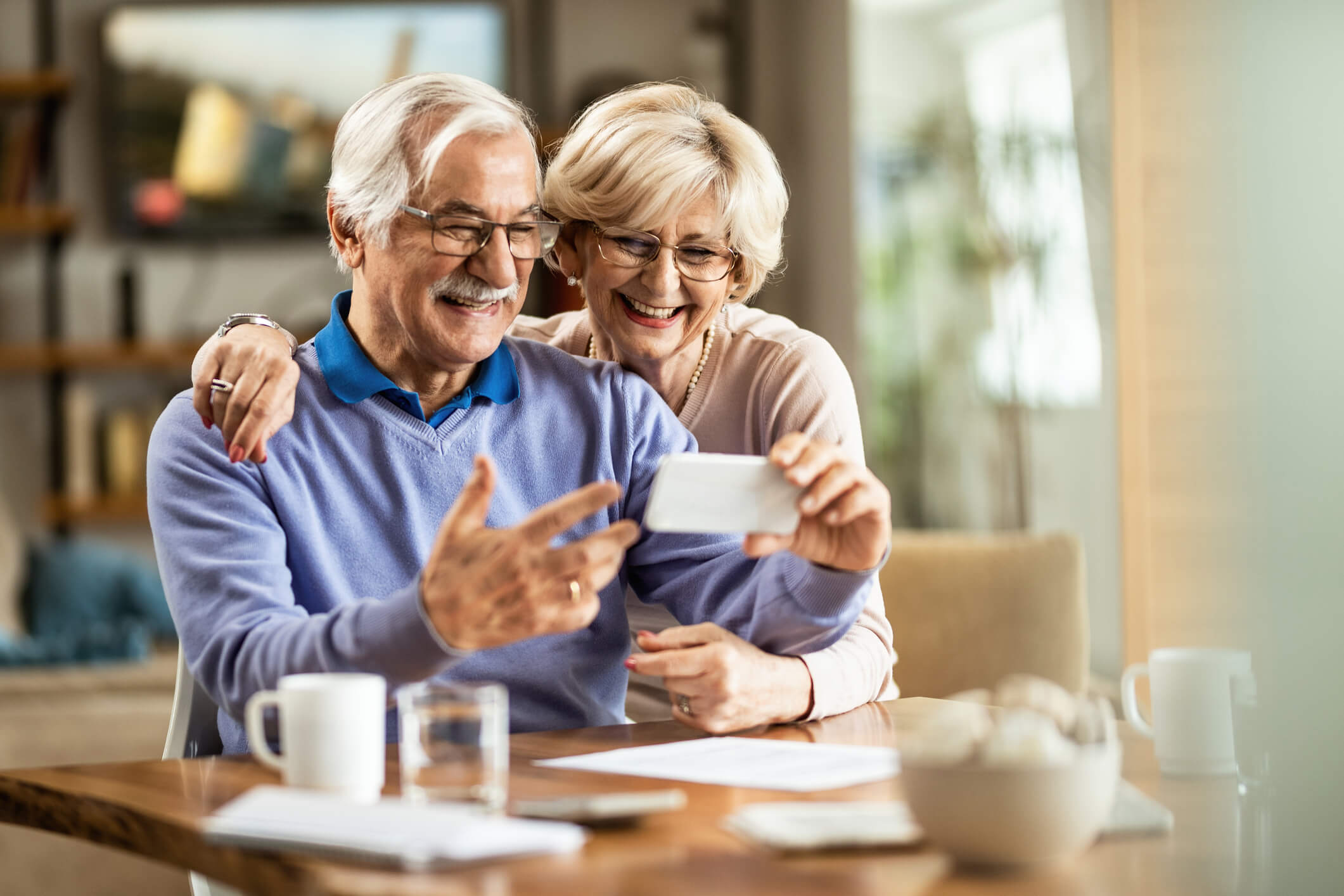 Senior couple smiling at phone