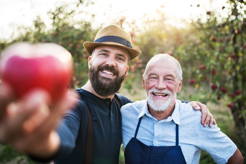 Two men in an apple field