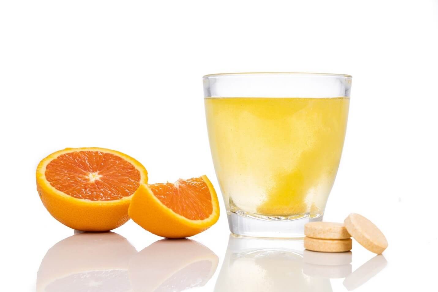 Vitamin C drink with orange slices and tablets