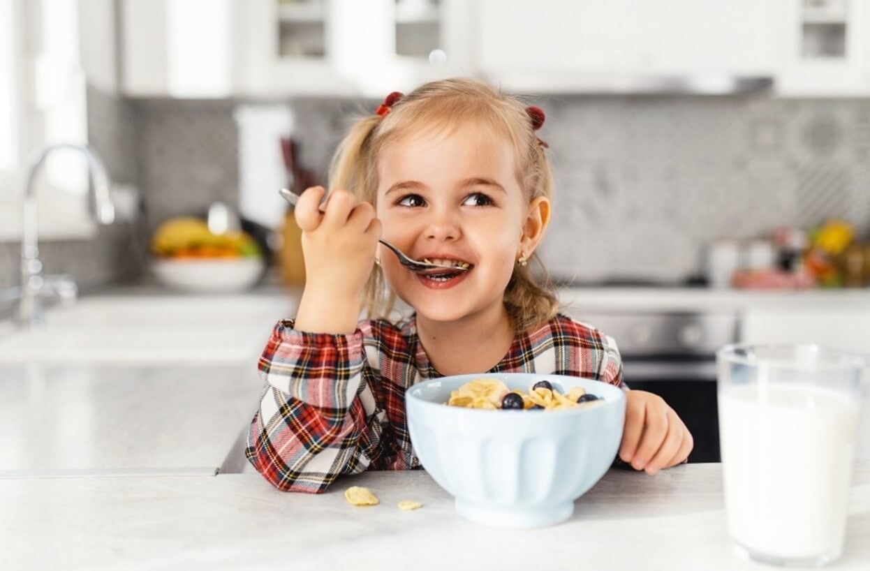 Little girl eating a bowl of cereal