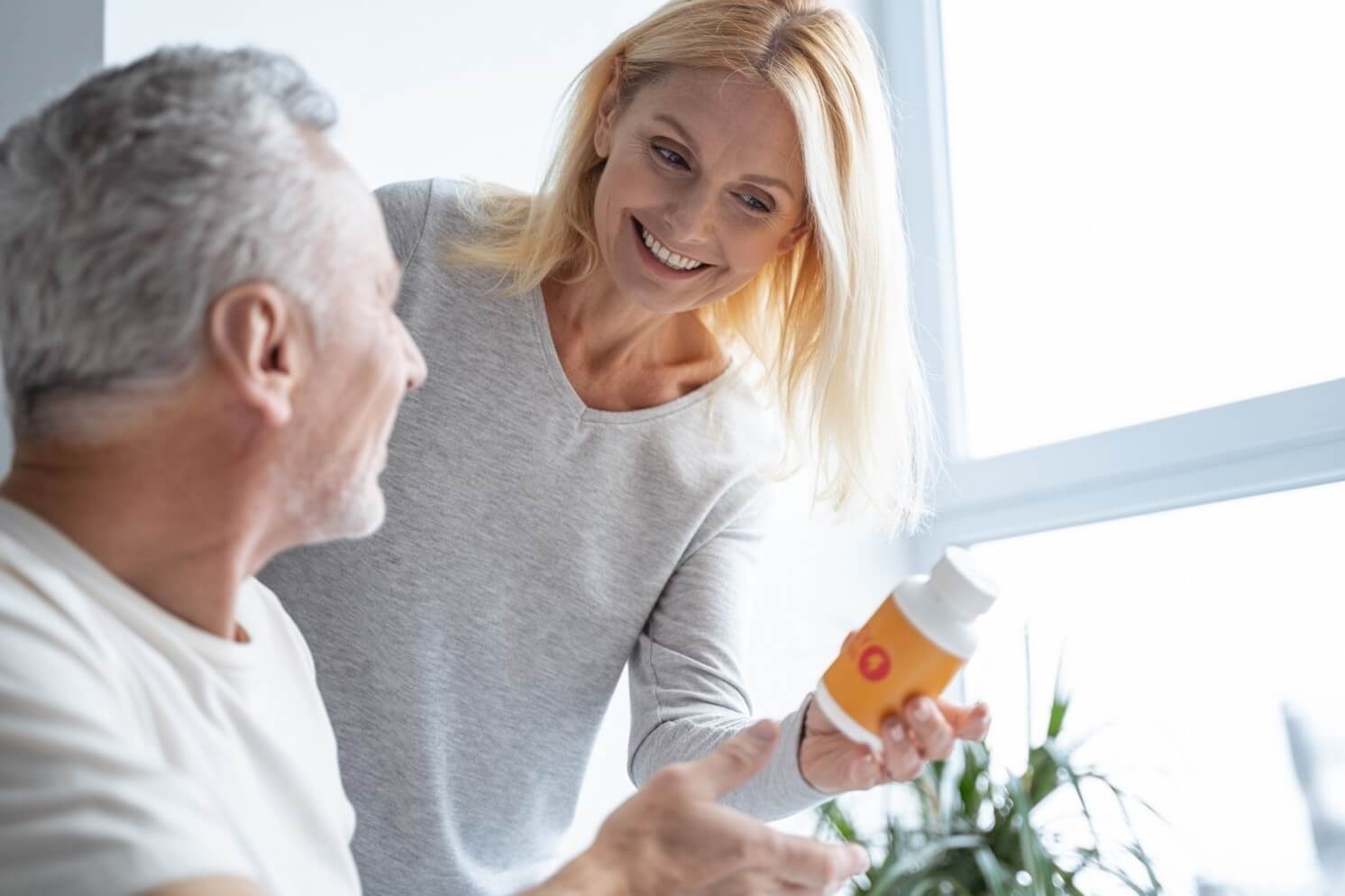 senior couple looking at supplement bottle