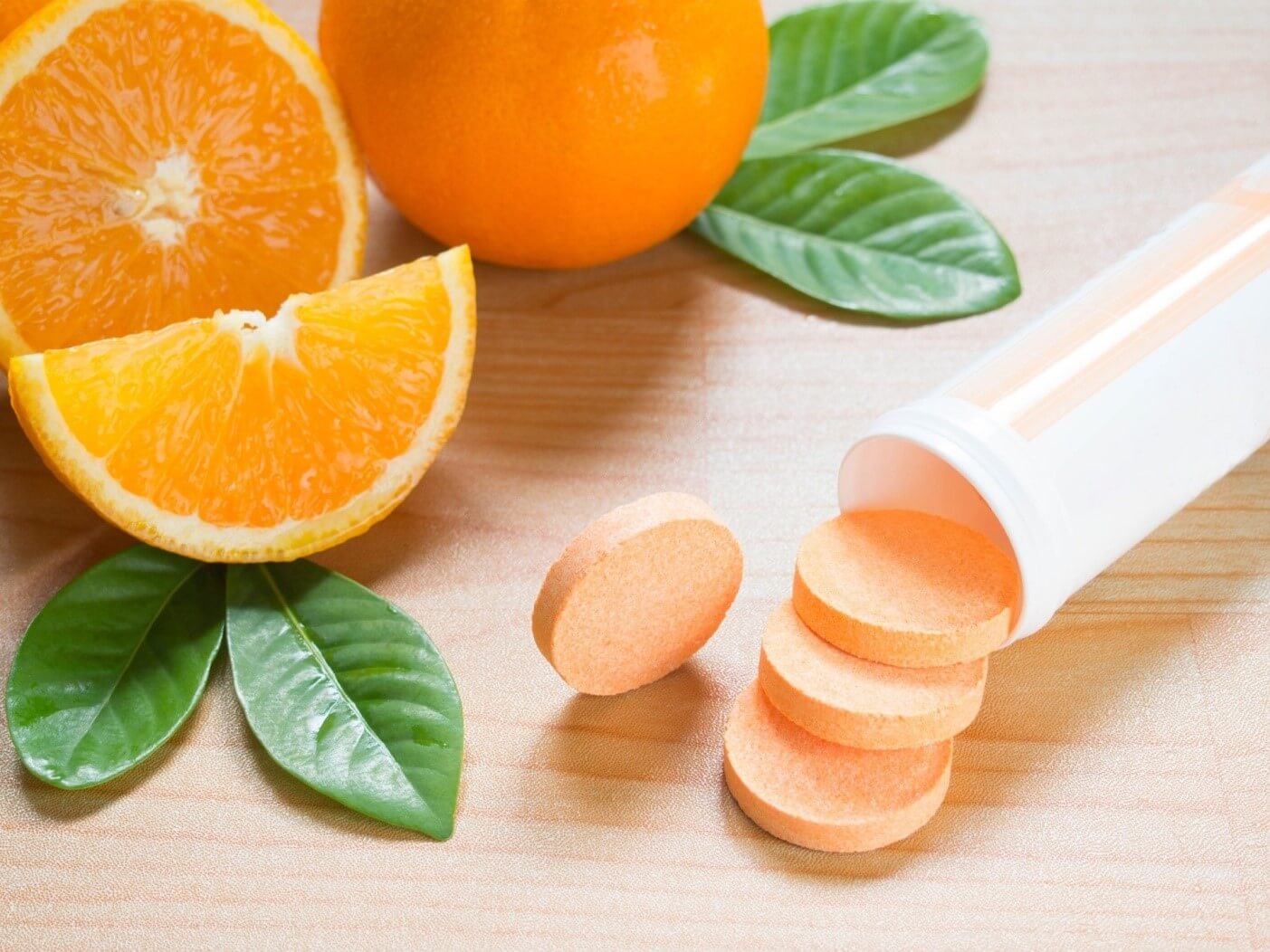 Vitamin C tablets and orange slices on a table