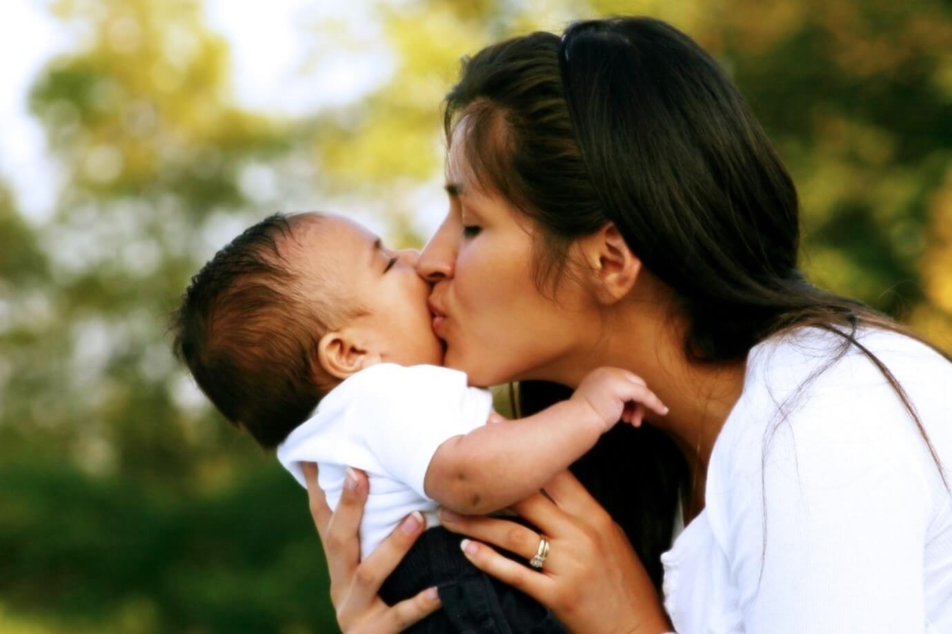 woman kissing a baby