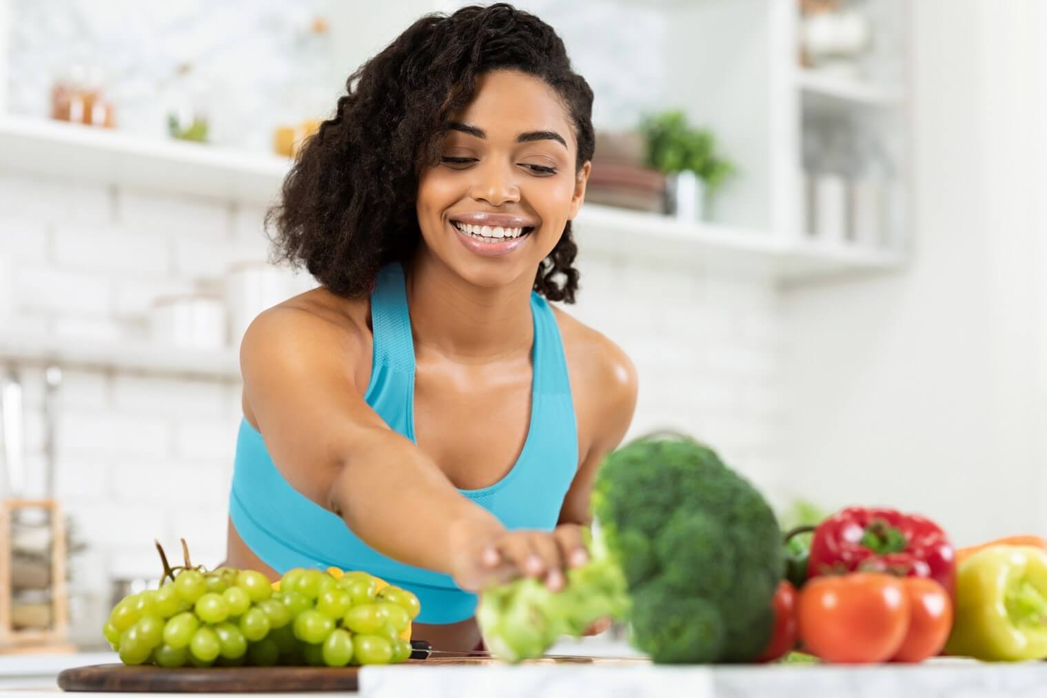 woman reaching for veggies in kitchen