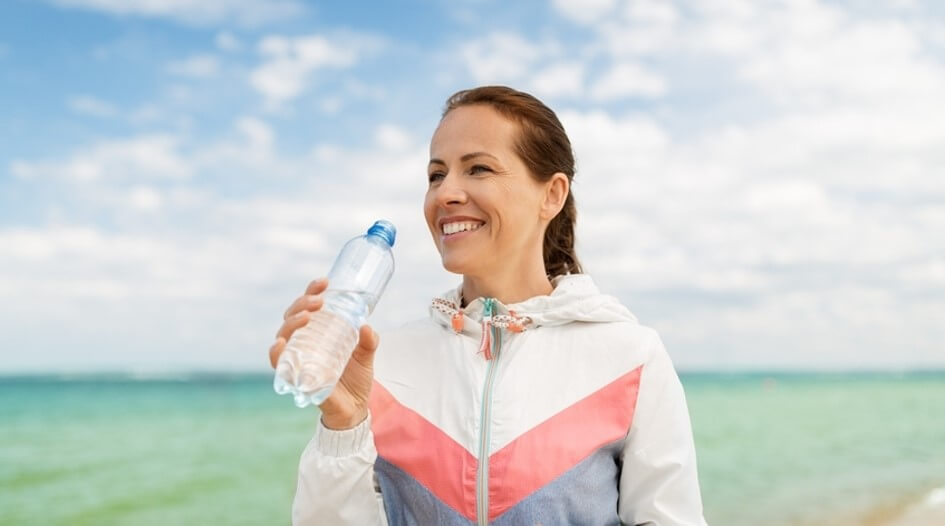 woman drinking water on beach