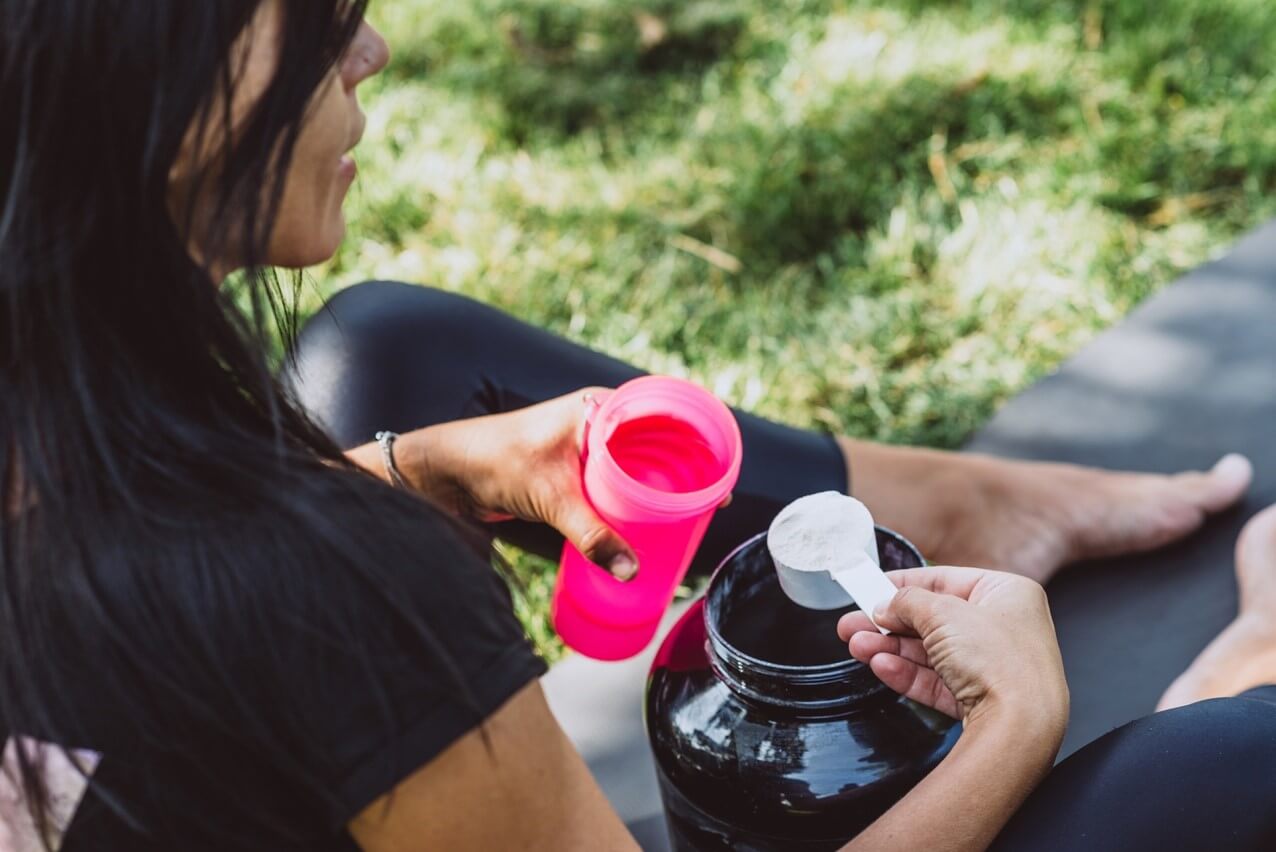 woman-pouring-protein-powder-into-drink