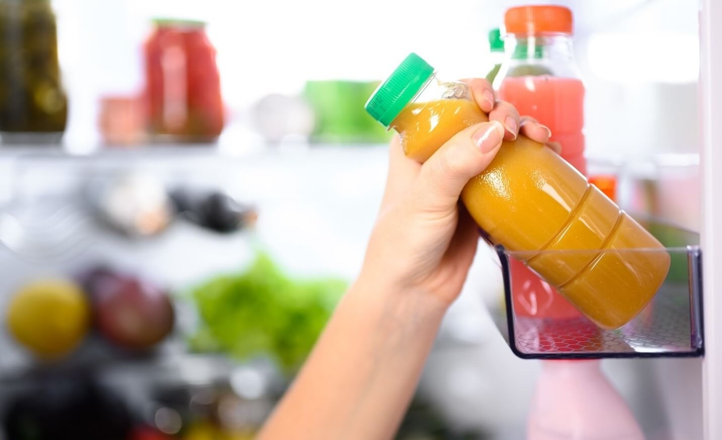 woman putting juice in fridge