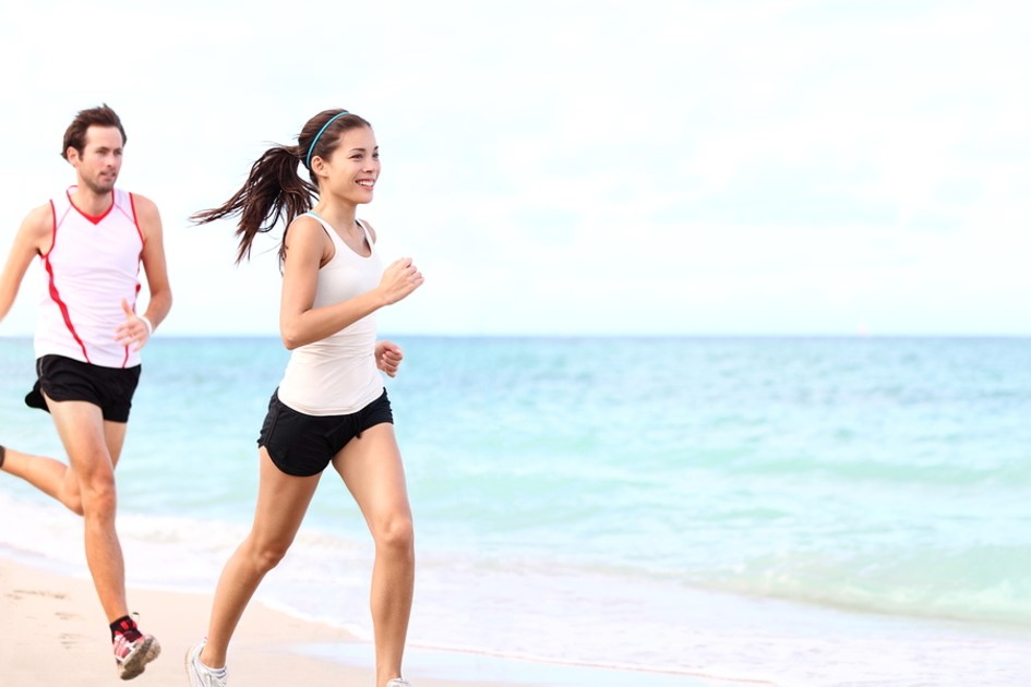 man and woman running on beach