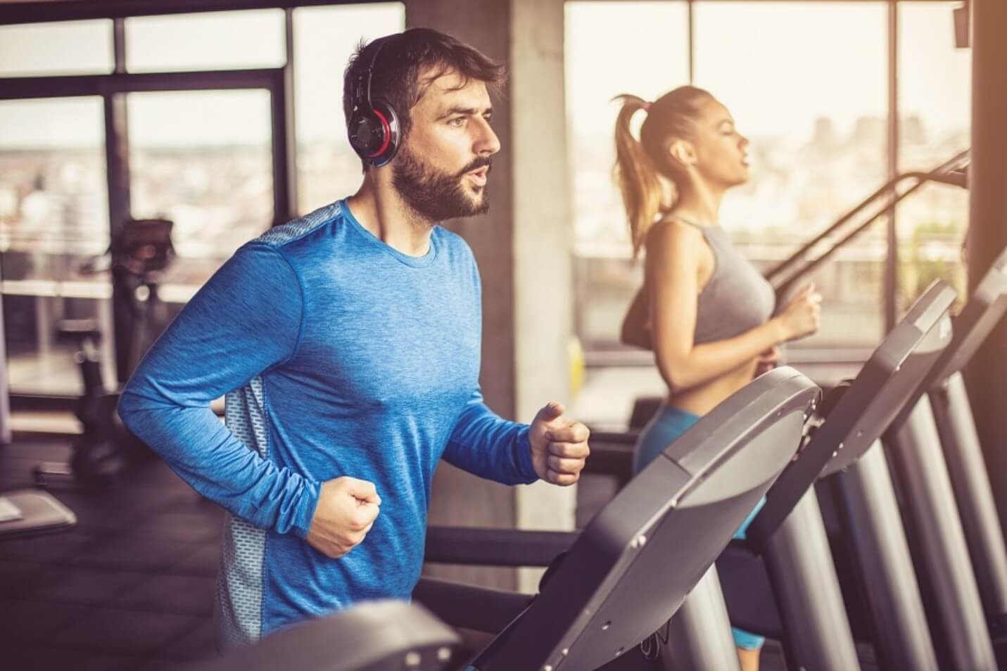 man and woman running on treadmill