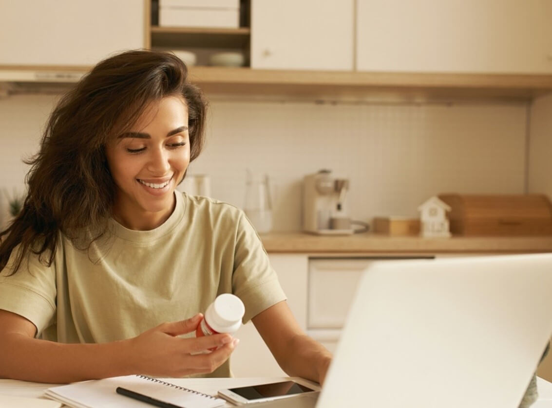 woman looking at pill bottle