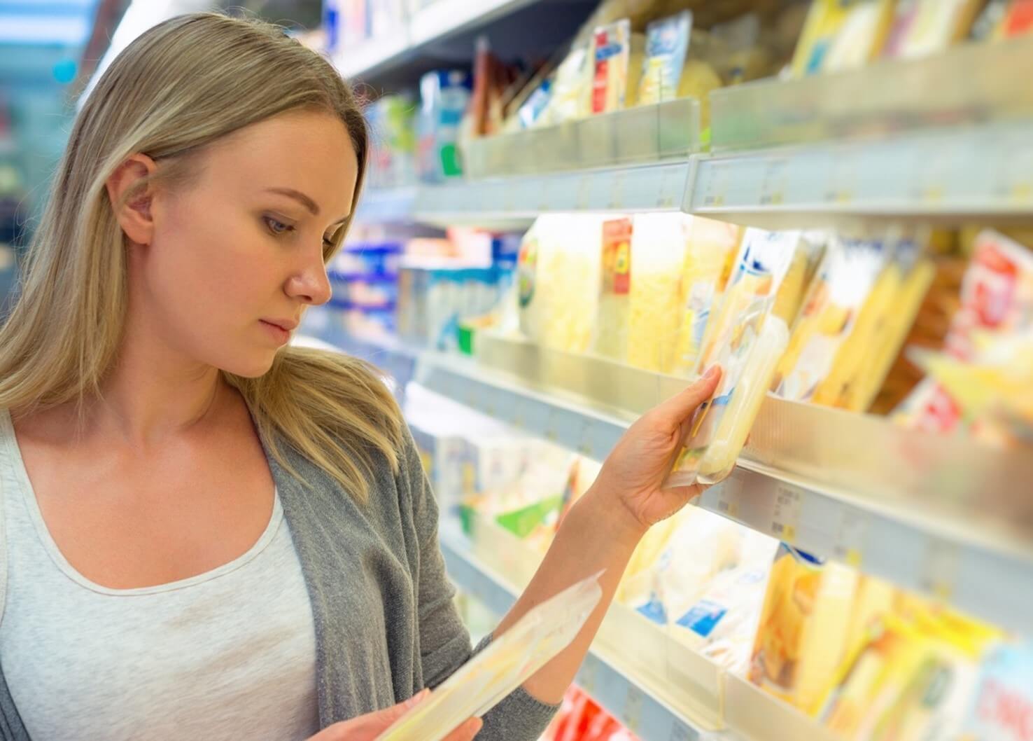 woman looking at cheese in store