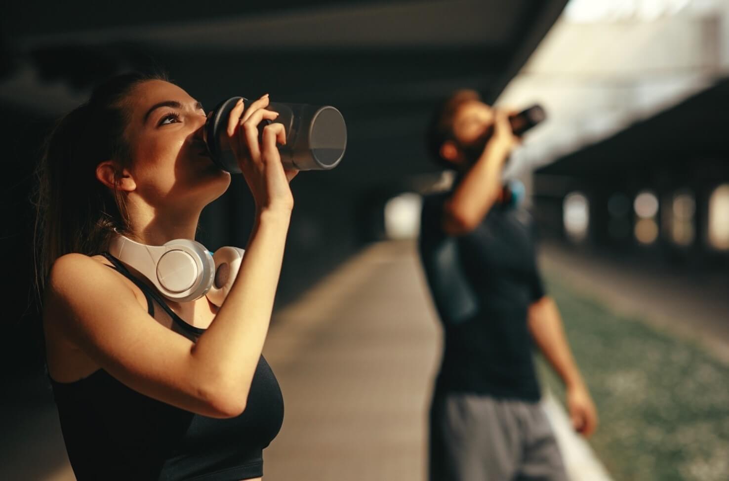 man and woman drinking protein shake
