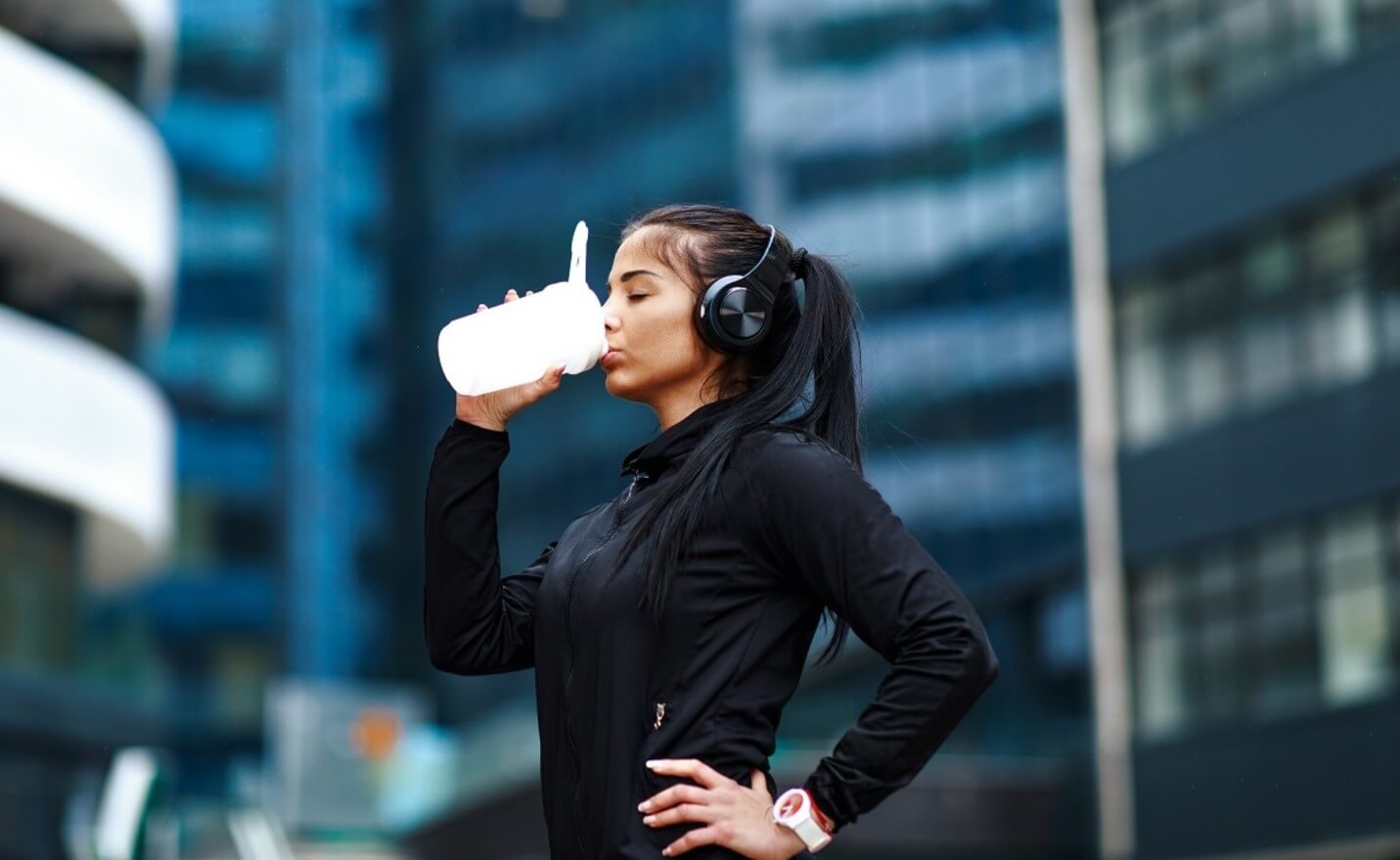 woman drinking water after working out