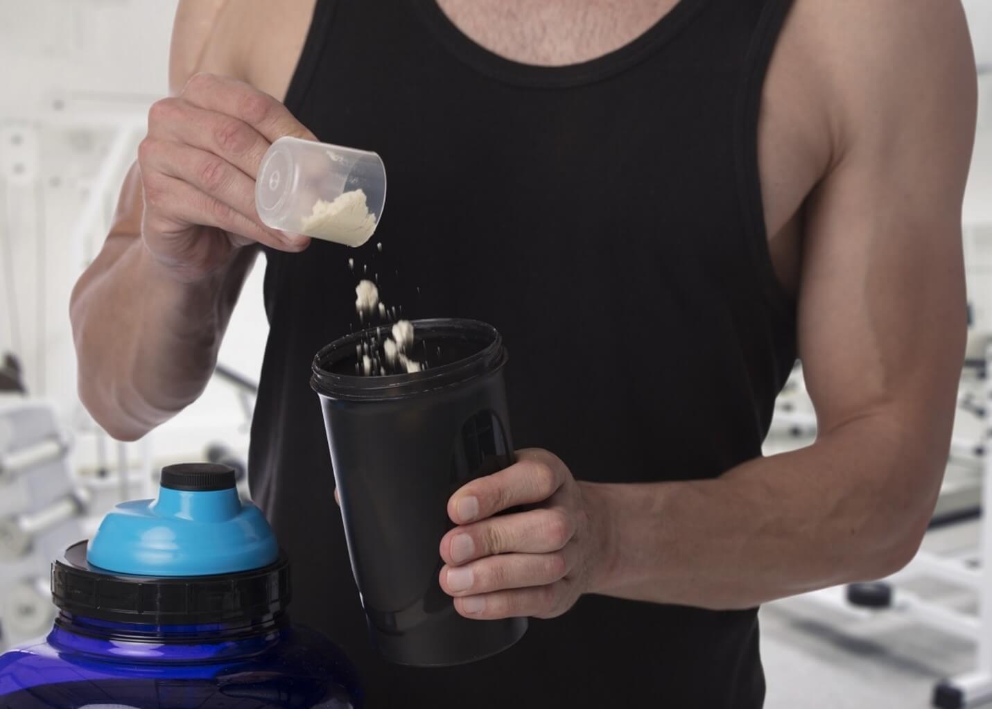 man pouring creatine in shaker