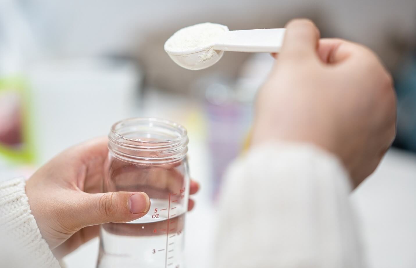 mom putting formula in bottle