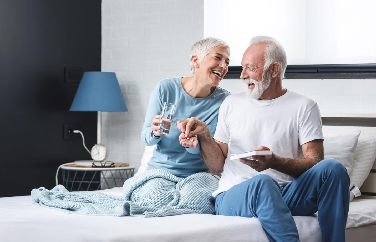 couple on bed taking supplements