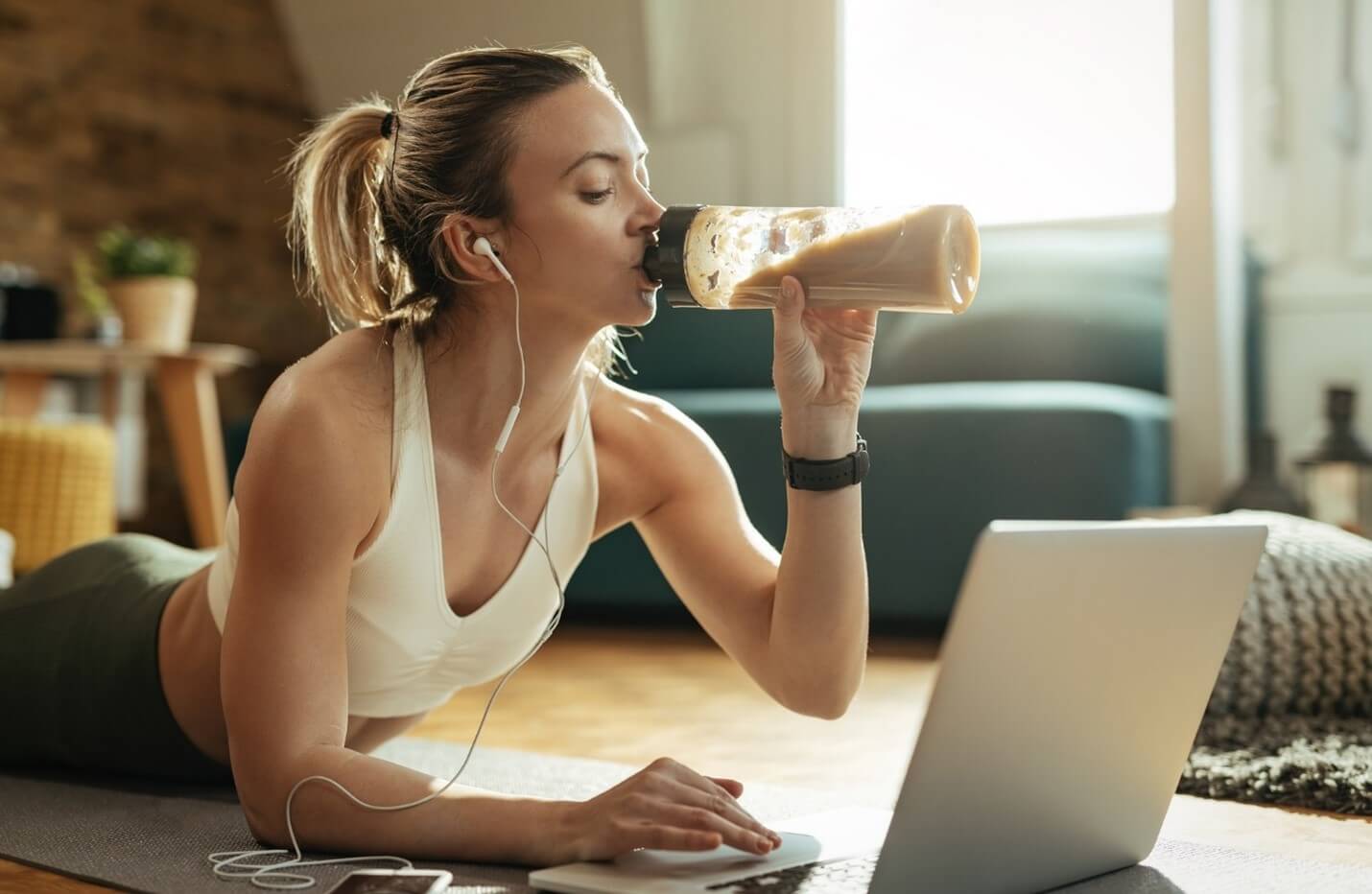 woman drinking shake with laptop