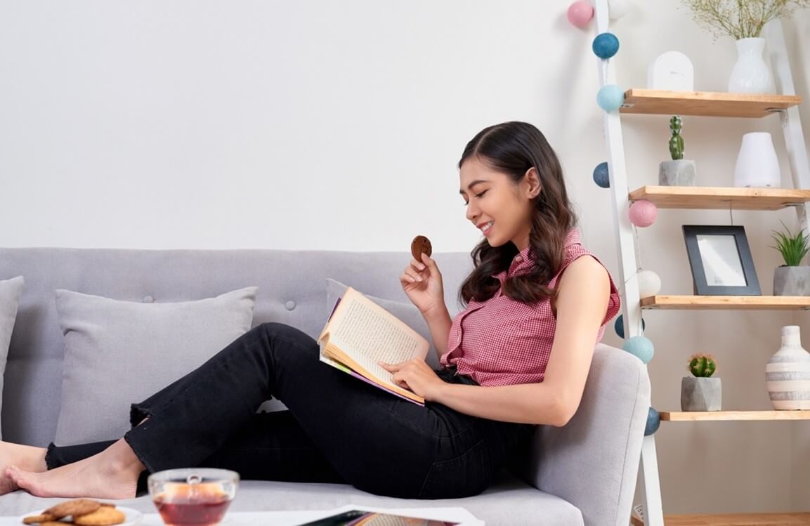 woman eating bar and reading