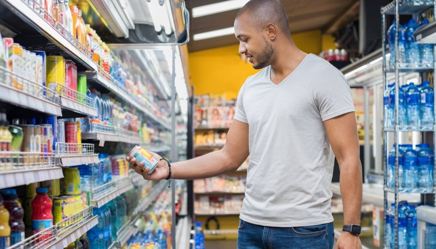 man looking at beverage in store