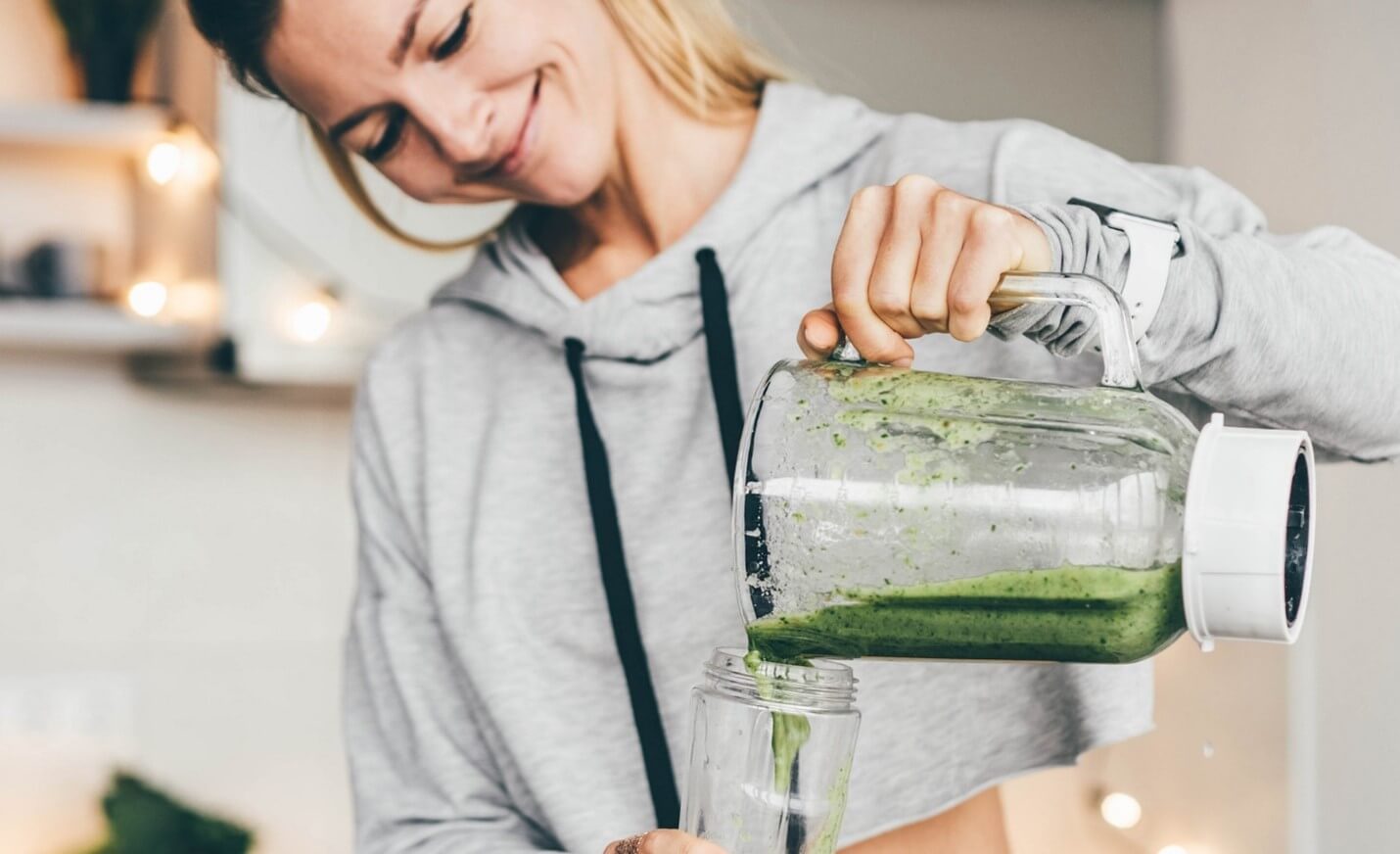 woman pouring green smoothie