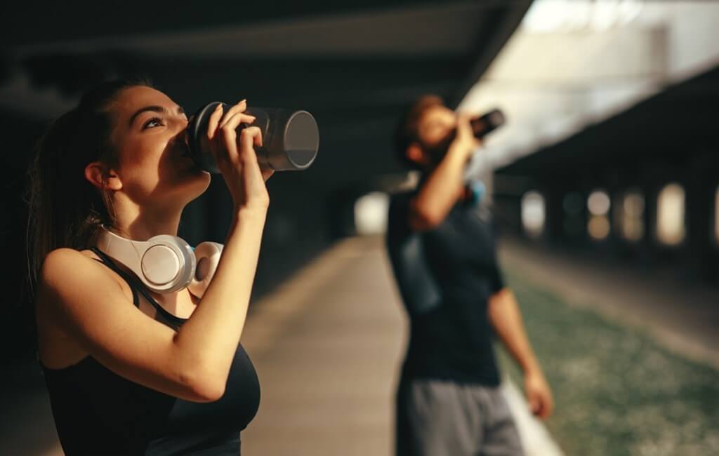 man and woman drinking protein shake