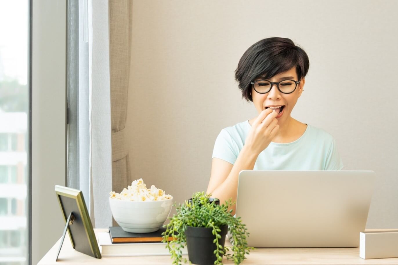 asian woman eating popcorn