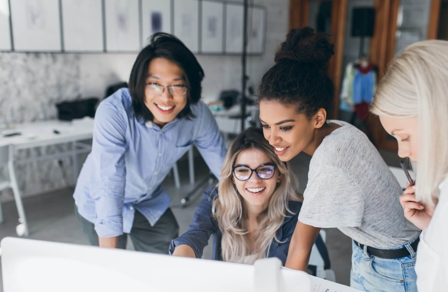 group of adults looking at computer