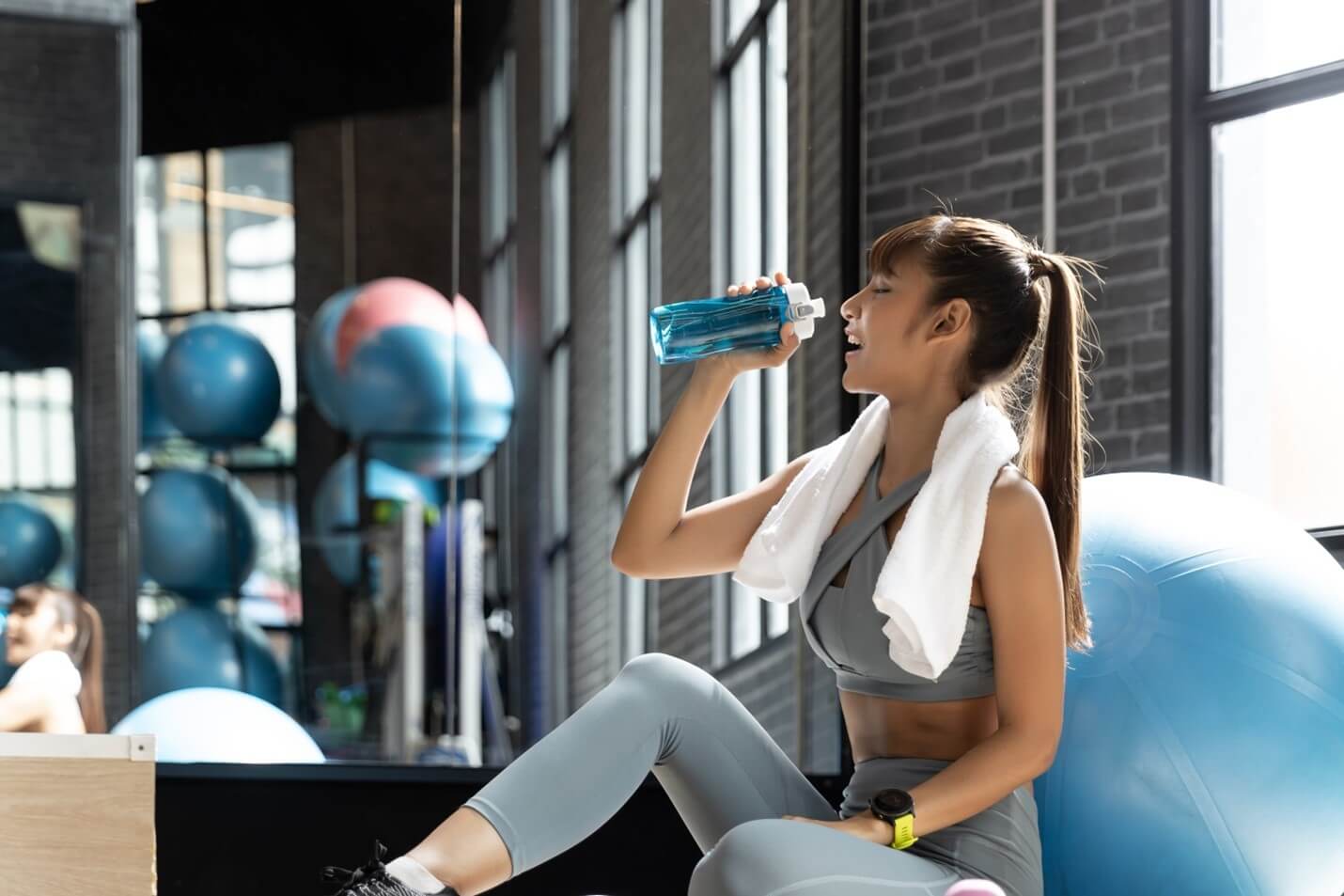 woman drinking water in gym