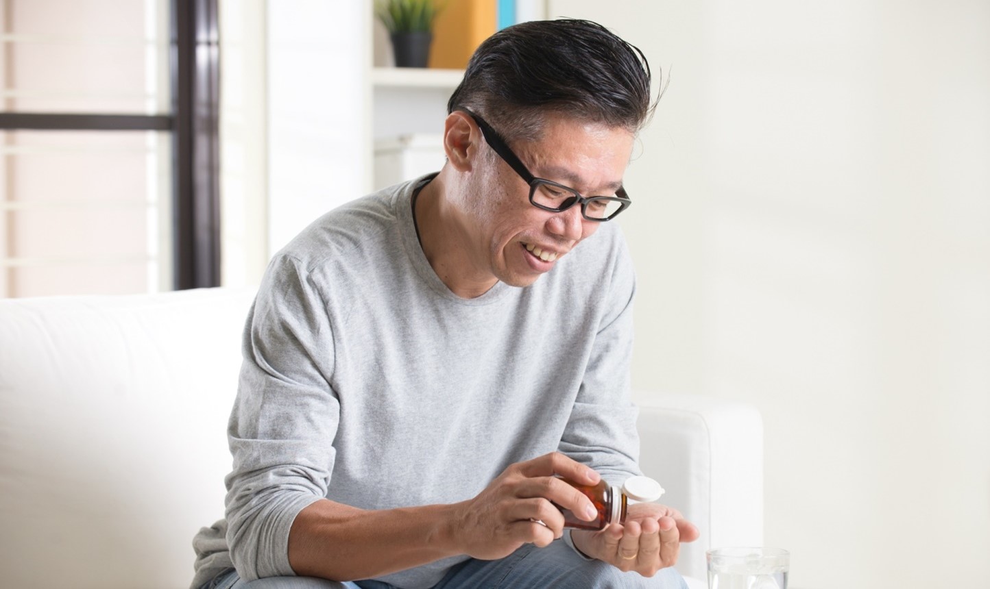asian man taking supplement 