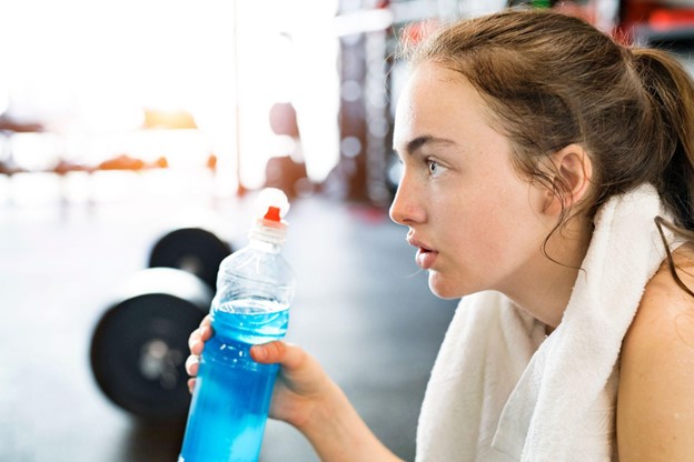 woman drinking beverage at gym