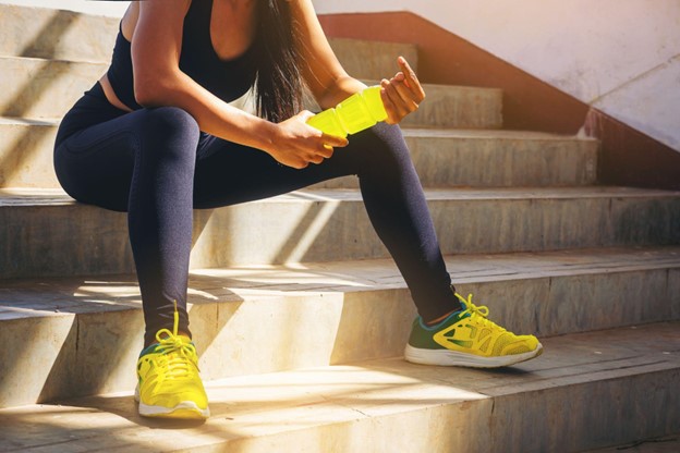 woman sitting on stairs after workout