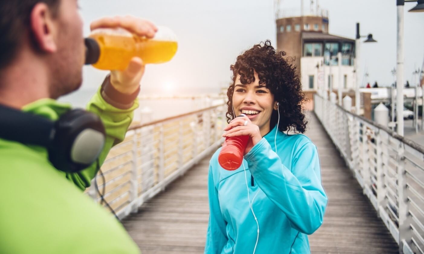 woman drinking beverage after exercising 
