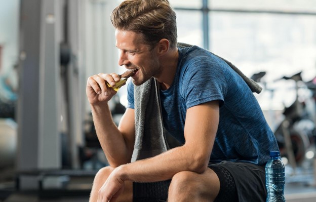 man eating bar at gym