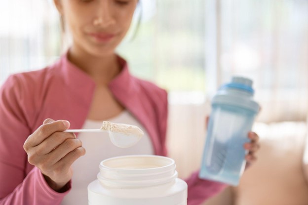 woman scooping collagen powder