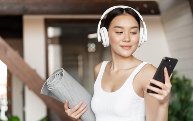 woman holding yoga mat on her phone