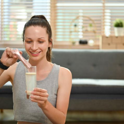 woman pouring powder mix into water