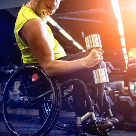 man in wheelchair lifting weight
