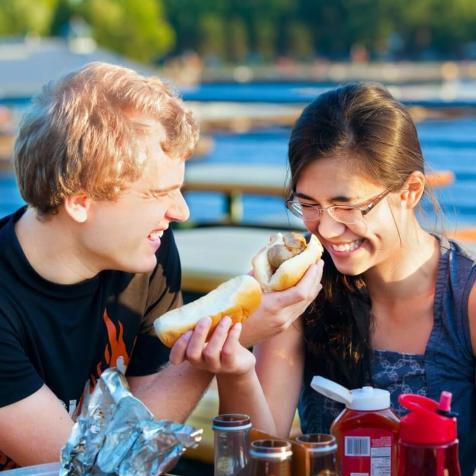two people eating hot dogs