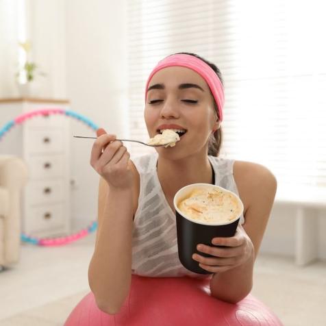 woman eating ice cream on exercise ball