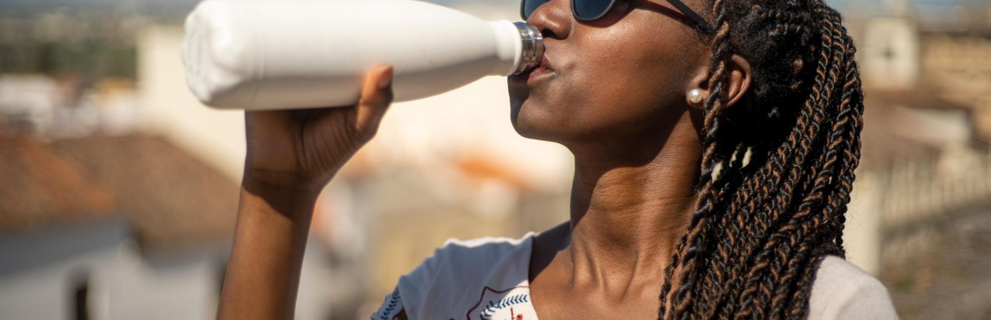 woman drinking out of water bottle