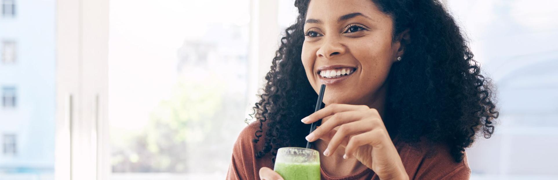woman drinking green smoothie