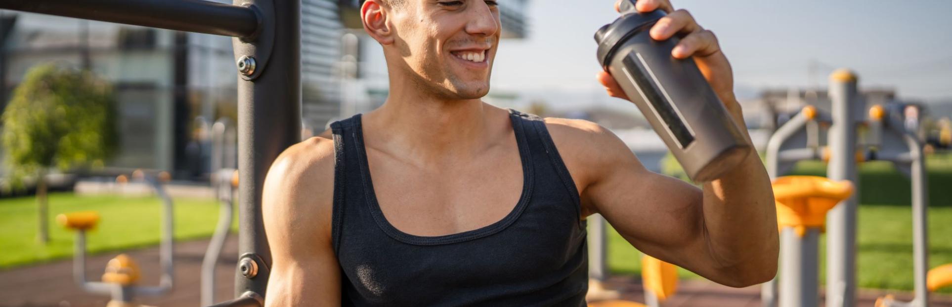 Man drinking protein shake outside