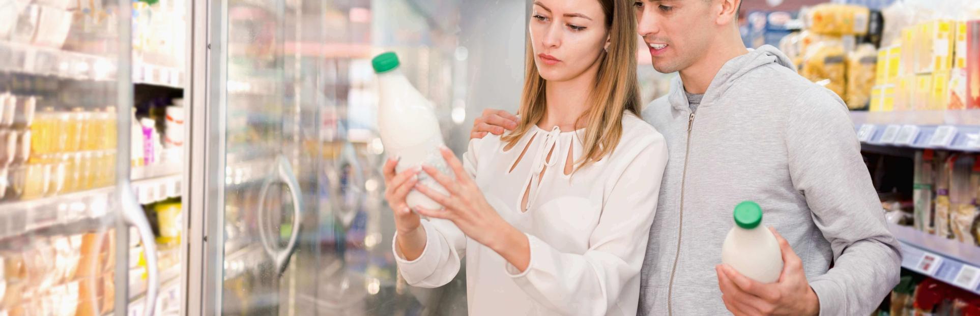 couple looking at milk in grocery store