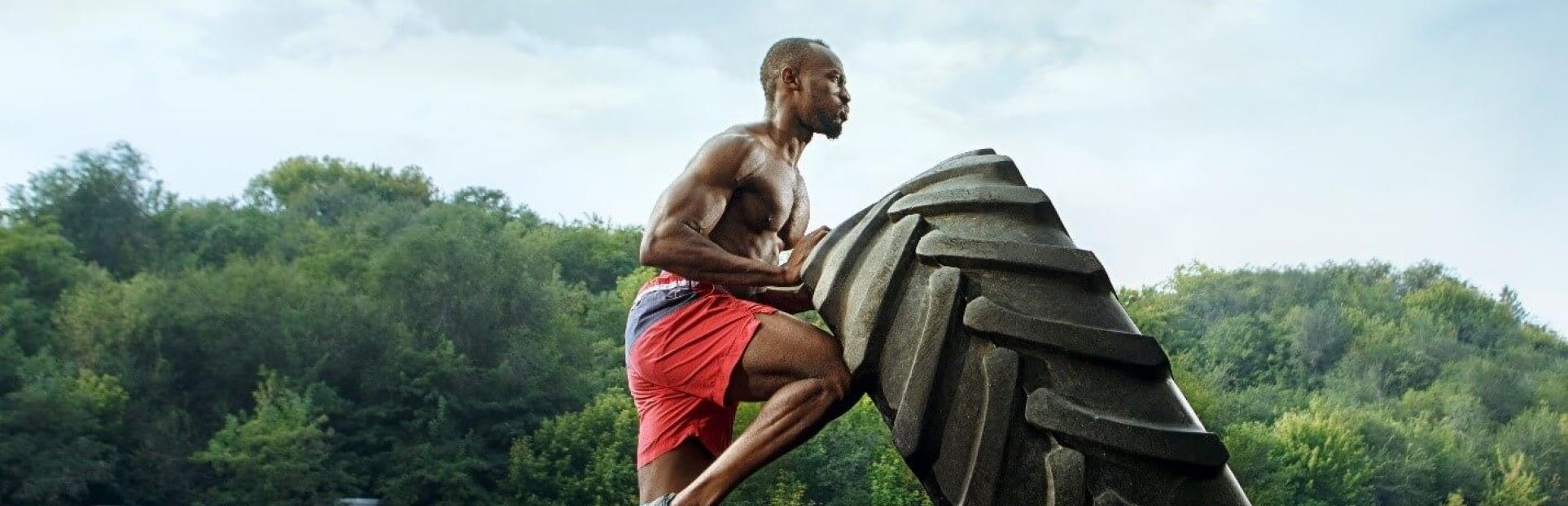 man pushing tire