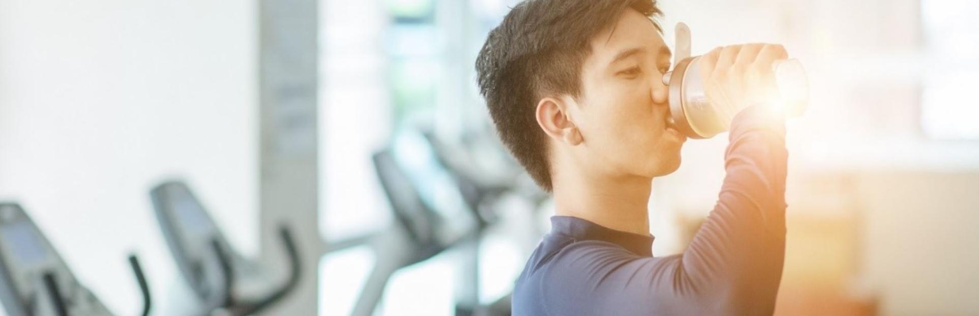 man with pre-workout beverage in gym gn