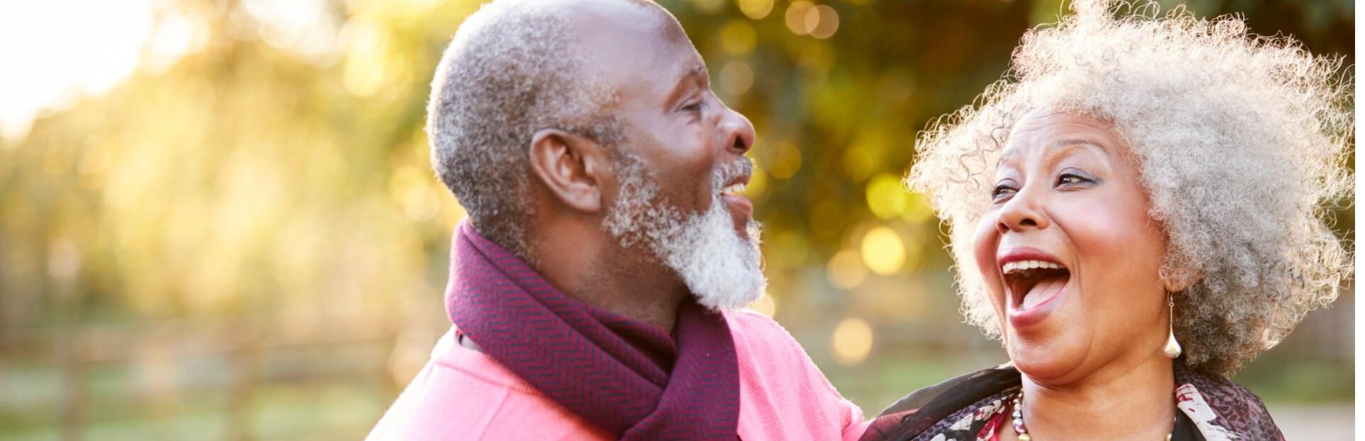 Senior couple laughing outside